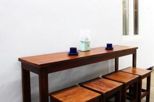 a wooden table with two cups on top of it at House of Dharmawan in Surabaya