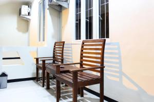 two wooden chairs sitting in front of a window at House of Dharmawan in Surabaya
