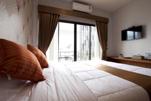 a bedroom with a large bed with a large window at 777 Food & Bed in Chiang Rai