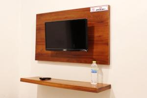a flat screen tv on a wall with a bottle of water at House of Dharmawan in Surabaya