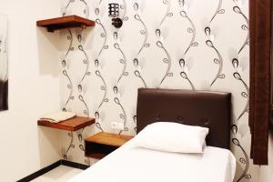 a bedroom with a bed with a black and white wall at House of Dharmawan in Surabaya