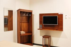 a bedroom with a flat screen tv on a wall at House of Dharmawan in Surabaya