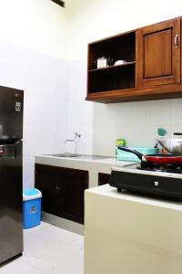 a kitchen with a black refrigerator and a sink at House of Dharmawan in Surabaya