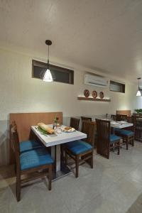 a dining room with chairs and a table and a table and chairsktop at The Eastern Hotel in Ankleshwar