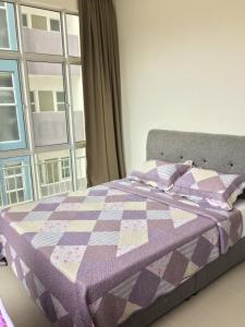 a bed with a quilt on it with a window at Cameron Barrington Square 1Room @ Golden Hill in Cameron Highlands