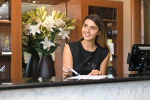 a woman sitting at a counter in a store at Best Western Sanctuary Inn in Tamworth