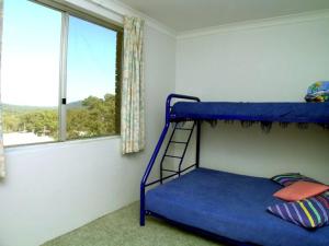 a bedroom with a bunk bed and a window at Blue Waters Unit 8 59 Ronald Avenue in Shoal Bay