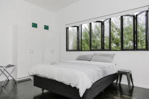 a bed in a white room with windows at Mata Manea in Rarotonga