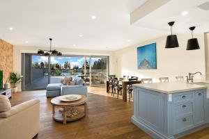 cocina y sala de estar con sofá y mesa en Belle Vue- Penthouse at Black Beach en Kiama