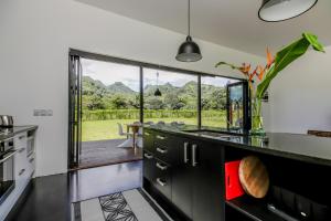 a kitchen with a sink and a large window at Mata Manea in Rarotonga