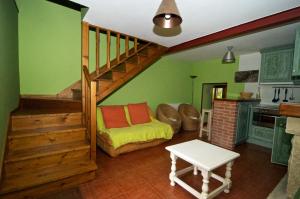 ein Wohnzimmer mit einem Sofa und einer Treppe in der Unterkunft Hotel y AR Palacio Flórez Estrada in Pola de Somiedo