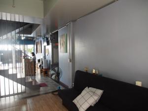 a living room with a black couch and a staircase at Sriyanar Place in Bangkok