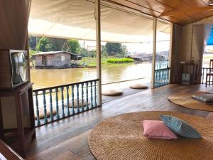 ウタイターニーにあるU Pae PaeStay Uthaithaniのラグ付きの川の景色を望む客室です。