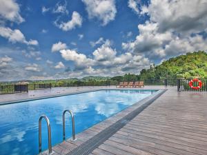 a swimming pool with a wooden deck and a blue sky at Oak Ray Regency in Kandy