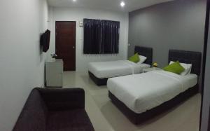 Habitación de hotel con 2 camas y sofá en The Clover Lampang en Lampang