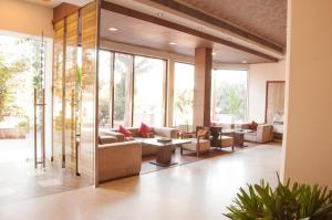 eine Lobby mit Sofas, Tischen und Fenstern in der Unterkunft Hotel Gwalior Regency in Gwalior
