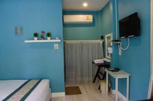 een blauwe kamer met een bed en een televisie bij Ban Krut Resort in Ban Krut