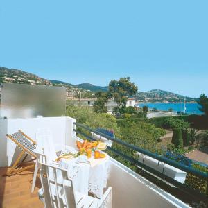 balcón con mesa y sillas y vistas al océano en Logis Hotel l'Esterella, en Agay - Saint Raphael