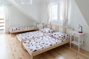 een slaapkamer met 2 bedden en een raam bij Na Fali in Gdańsk