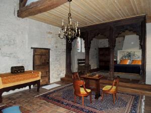 a room with a bed and a table and chairs at Maison Romane 1136 in Cluny +19 photos