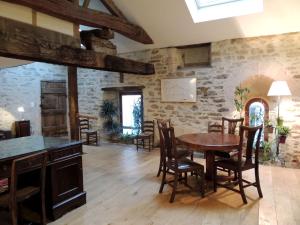 - une salle à manger avec une table et des chaises en bois dans l'établissement Maison Romane 1136, à Cluny