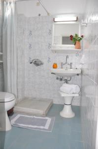 a bathroom with a sink and a toilet and a mirror at Alexandra Rooms in Malia