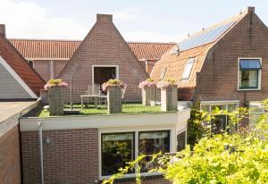 a brick house with flowers on the roof at Bij de Buren in Enkhuizen