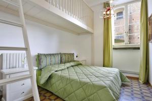 a bedroom with a green bed and a staircase at B&b Pergola House in Lucca