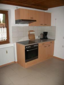 a kitchen with wooden cabinets and a stove top oven at Haus Alpenrose in Schwangau