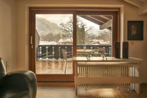 ein Wohnzimmer mit einer großen Glastür zu einem Balkon in der Unterkunft Alpen Deluxe Oberammergau in Oberammergau
