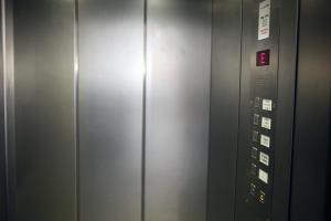a elevator with a metal door with a sign on it at Hotel Lafayette in Hamburg
