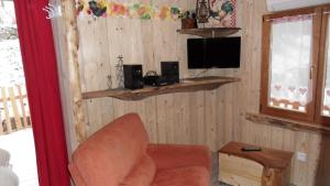 a living room with a chair and a television at La roulotte du bucheron in Lapoutroie