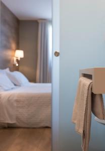 a hotel room with a bed and a towel on a door at Hotel L'Algadir del Delta in Poblenou del Delta