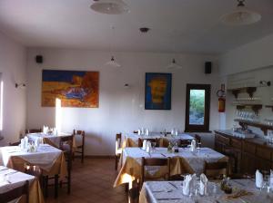 a dining room with tables and chairs with white tablecloths at La Nuvola sul Mare in Vara Superiore