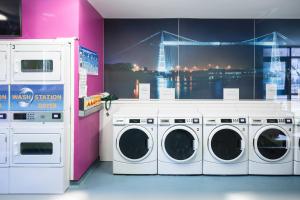 a laundry room with three washing machines and a large window at Newport Student Village (Campus Accommodation) in Newport