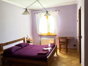 a bedroom with a bed and a table and a window at La Nuvola sul Mare in Vara Superiore