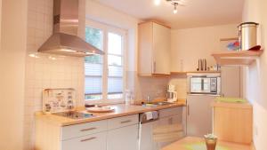 eine Küche mit weißen Schränken, einer Spüle und einem Kühlschrank in der Unterkunft Villa Vineta Whg. 207 in Ahlbeck