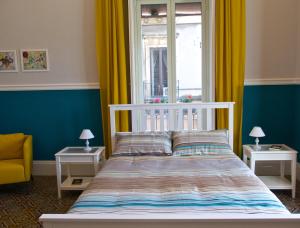 Schlafzimmer mit einem Bett und einem Fenster mit gelben Vorhängen in der Unterkunft B&B Umberto 134 in Catania