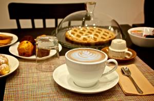 una mesa cubierta con una taza de café y un pastel en B&B Umberto 134, en Catania