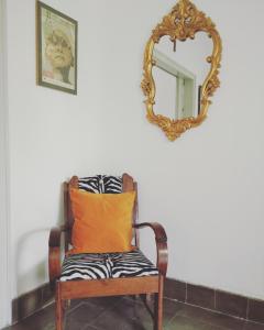 a chair with an orange pillow and a mirror at The Patio Yogya in Yogyakarta