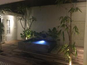 a room with potted plants and a large pool at The Patio Yogya in Yogyakarta