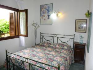 a bedroom with a bed and a window at Le Villette al Centro in San Teodoro