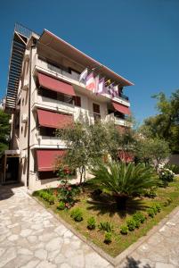 a building with balconies and a garden in front of it at Captain Apartments in Budva