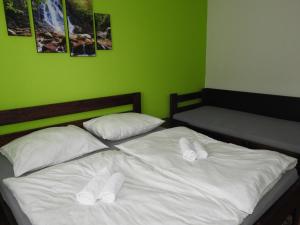 1 Schlafzimmer mit 2 Betten mit weißer Bettwäsche und Kissen in der Unterkunft Dovolenkový Dom Tatry in Vysoke Tatry - Tatranske Matliare