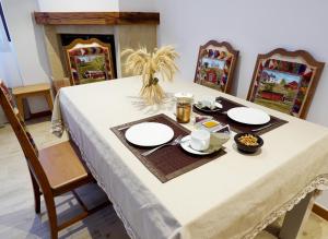 uma mesa com uma toalha de mesa branca e pratos sobre ela em Casa Rural Arriagaetxea em Lagrán