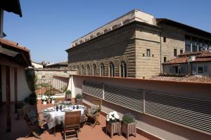 a patio with a table and chairs on a balcony at Tornabuoni Suites Collection Residenza D'Epoca in Florence