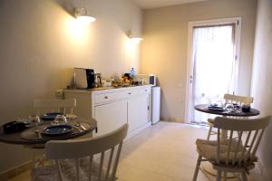 una cucina con tavolo e due sedie e una cucina con bancone di Avion B&B a Cagliari