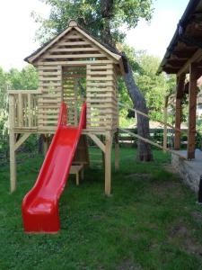 a playground with a red slide and a wooden house at Casa Emma Ház in Sovata