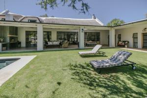 a yard with two lounge chairs and a house at The Whyte House in Graaff-Reinet