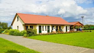 a house with an orange roof on a green lawn at Ferienwohnung Hof Maiweg in Alt Schönau +10 photos